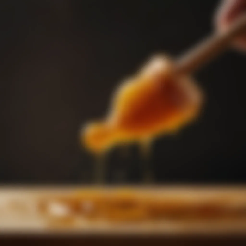 Golden honey dripping from a wooden honey dipper